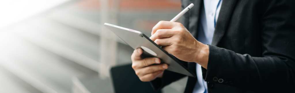 Home de negocios firmando documento en una tablet.